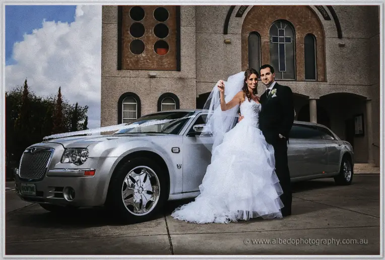 Michele throws her veil in celebration beside the silver limousine out the front of the church.