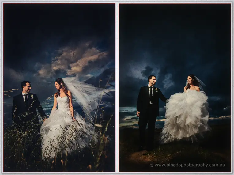 Laughing in windswept grass, Michele lifts her gown while dark storm clouds roll behind the newlyweds.