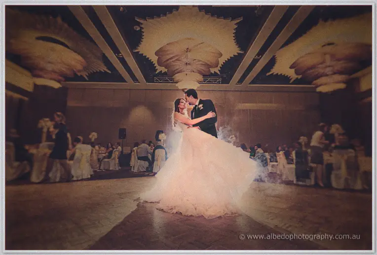 Wreathed in mist, Michele and Nick share their first dance under the glowing ballroom ceiling.