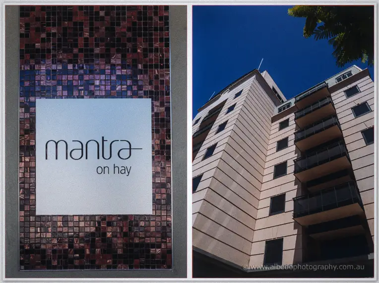 Tiled hotel sign reading Mantra on Hay beside a sunlit high-rise facade under a deep blue Perth sky