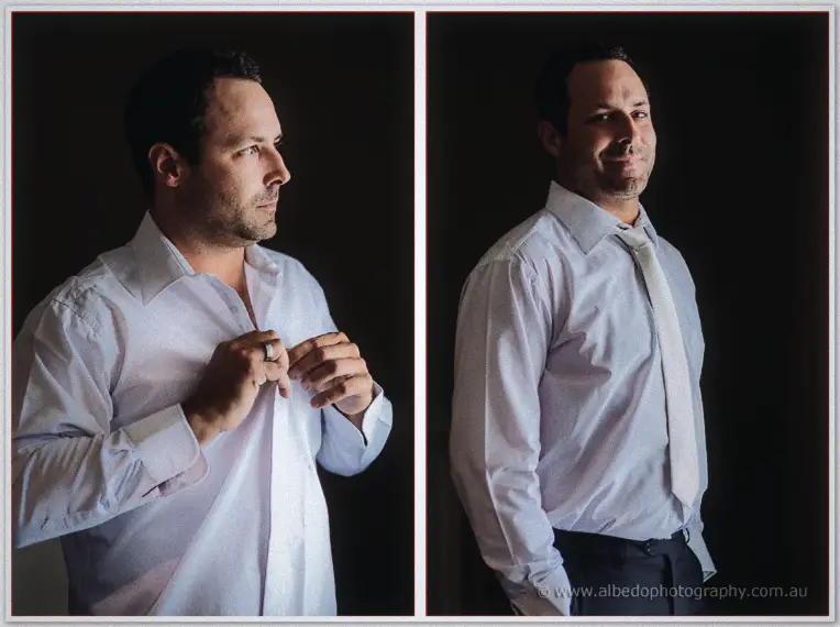Two-frame portrait of the groom buttoning his white shirt and straightening his tie in moody window light