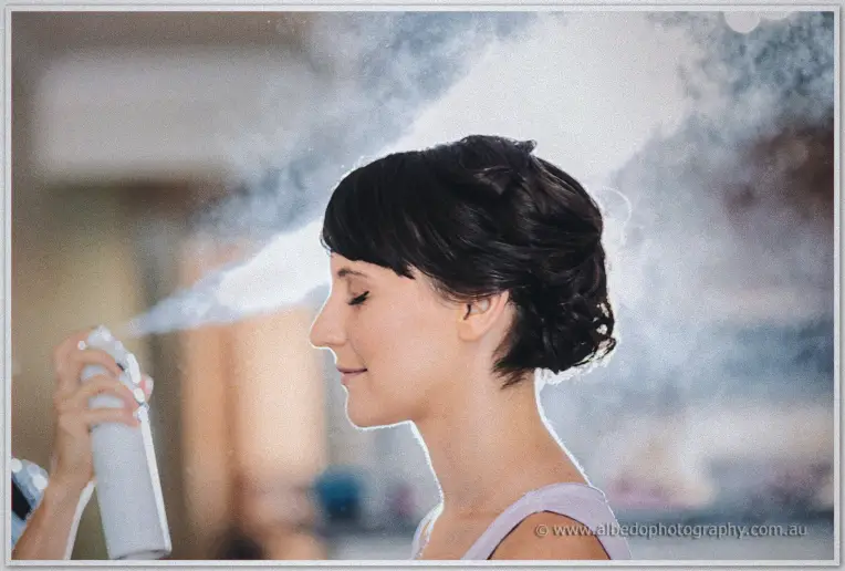Hairspray mist clouding around Allison's pinned curls during bridal preparations in the hotel room