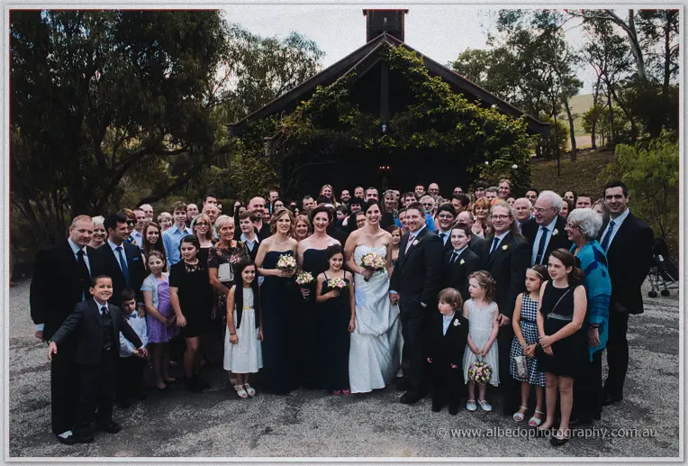 All the guests gather before the ivy-covered chapel at Inglewood Estate for a wide group photograph.