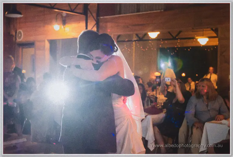 Felicity hugs a guest tightly while guests film the lively dance floor.
