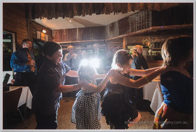 Felicity dances with her father in the barn as guests watch and film.