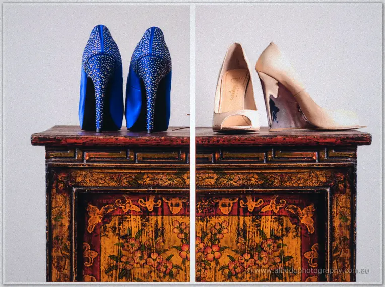 Blue crystal-encrusted heels and peep-toe wedges lined up on an ornately painted timber chest.