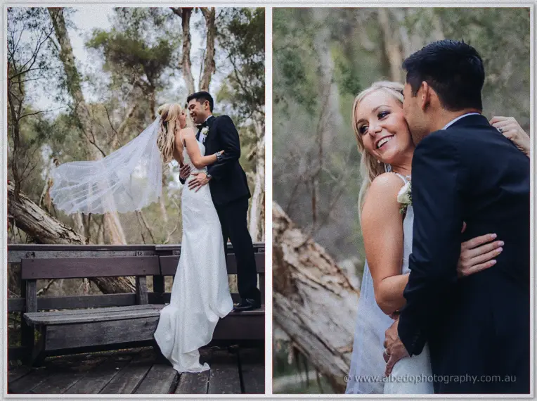 Chris kisses Kristyn's cheek as her long veil lifts in the breeze on a wooden deck among the trees