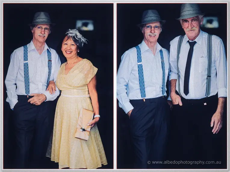 Wedding guests in striped braces and trilbies pose with a lady in a buttercup dress and feathered fascinator