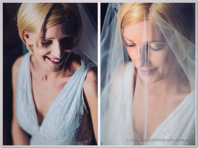 Bride Tansy smiles softly in her lace gown as her veil drifts across her face in warm window light