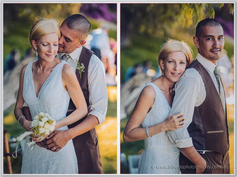 Tansy and Ciaran embrace beside a fallen log in the golden picnic light at Mosman Park