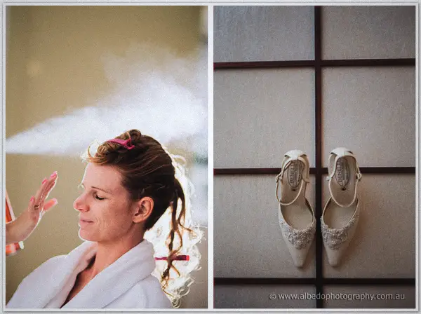 Bridesmaid's curls are sprayed set beside a pair of ivory lace wedding shoes hanging on a screen