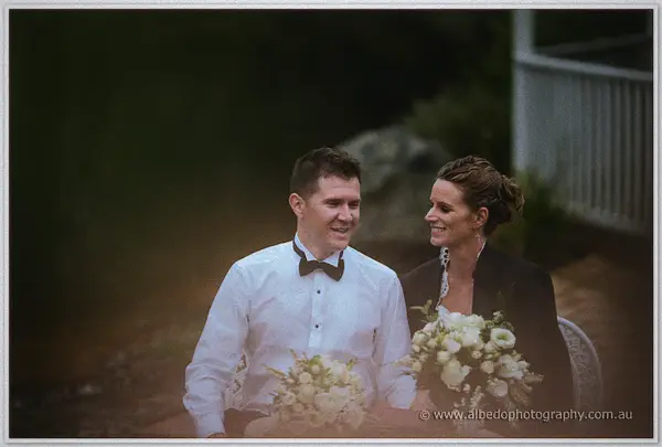 Groom in white shirt and bow tie laughing with the bride and her bouquet on a dusky Pemberton evening.