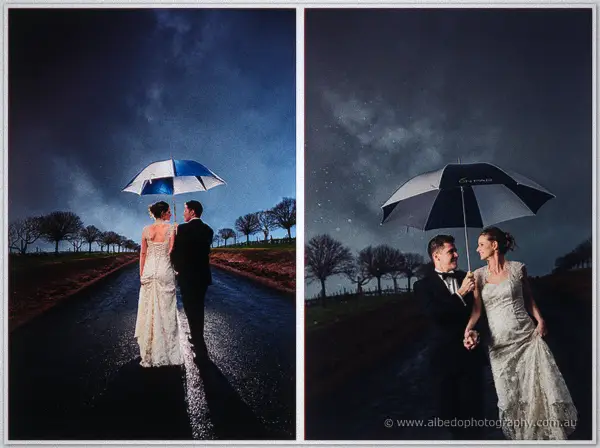 Bride and groom sheltering beneath umbrellas on a wet country road at moody dusk.