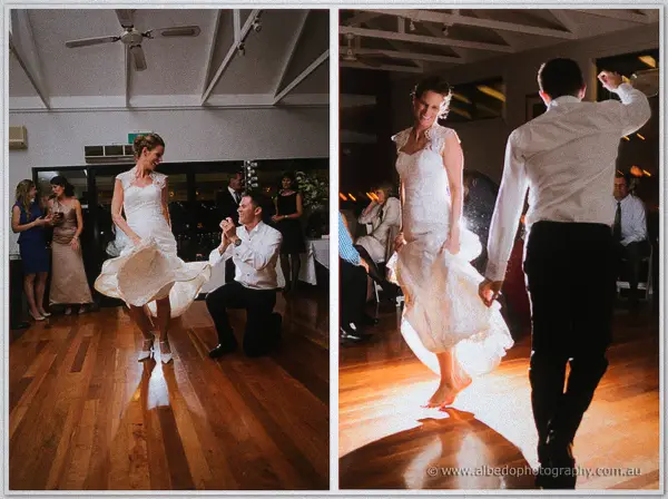 Bride kicking up her gown as the kneeling groom claps on the dance floor at Silkwood.