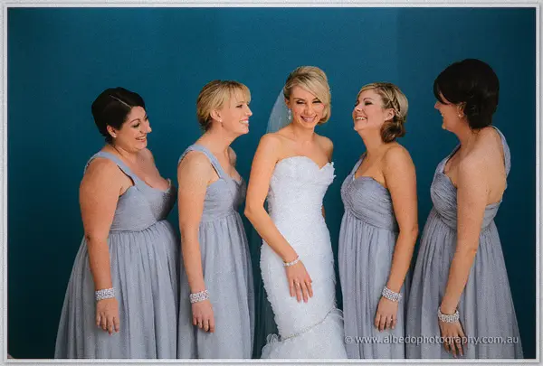 Sarah and her four bridesmaids double over laughing together, crystal bracelets jangling at their wrists