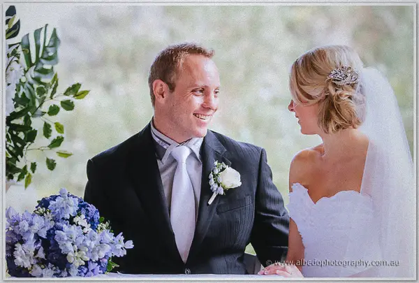 Nathan beams at Sarah as they exchange vows beneath greenery at the Wildflower Pavilion in Kings Park