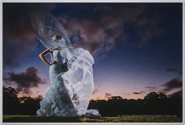 Sarah's veil lifts like smoke as she turns against a fiery sunset sky at Kings Park