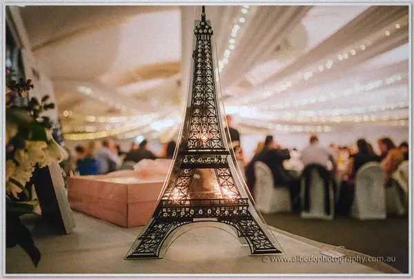 A lit Eiffel Tower keepsake ornament before the fairy-lit reception marquee at Joondalup Resort