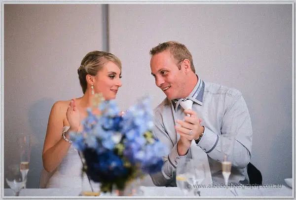 Sarah claps and Nathan pulls a goofy grin at the bridal table during the Joondalup reception