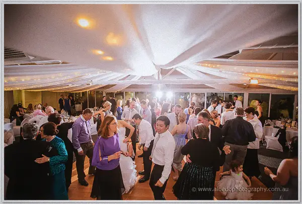 Guests pack the dance floor beneath glowing fairy lights as Sarah weaves through the crowd