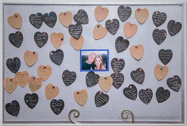 A framed photo of Sarah and Nathan ringed by handwritten paper heart well-wishes