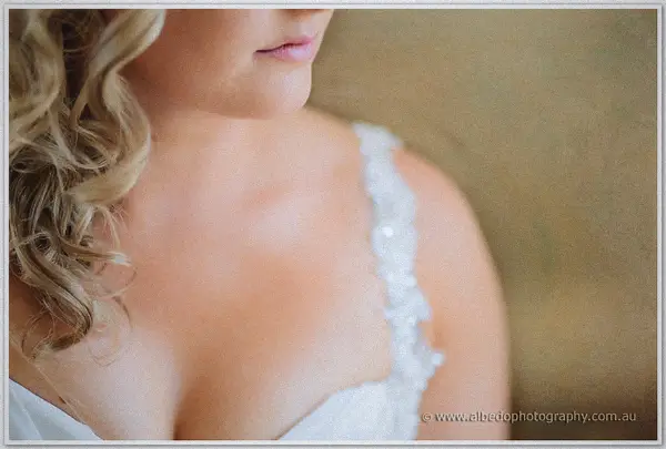 A soft close-up traces Ashley's lace shoulder strap and loose curls against warm skin tones