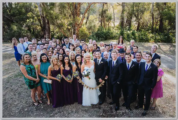 Every wedding guest gathered around the couple beneath tall gum trees
