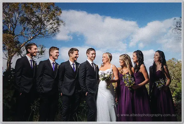 Ashley, Payden and their bridal party laughing together under a big open country sky