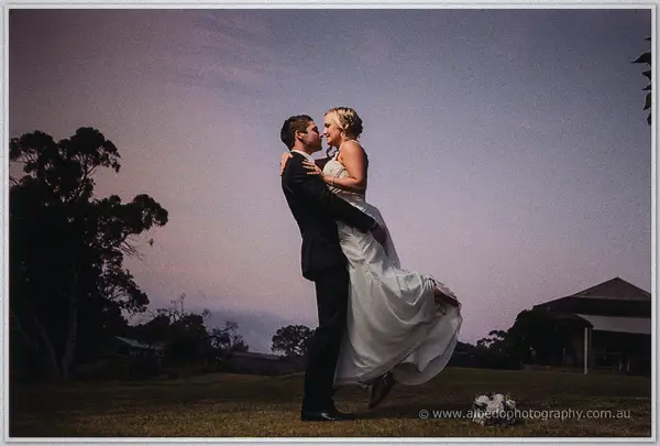 Payden lifts Ashley off her feet on a dusk lawn, her dress swirling beside the estate pavilion