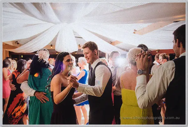 Guests pack the dance floor beneath swirling white drapery as the party gets going