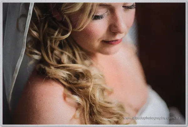 Soft profile of Tash, curls and veil falling over her shoulder as she looks down with a smile
