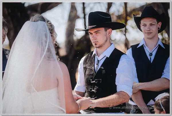 Gary says his vows with quiet focus while his best man and the celebrant stand beside the veiled bride.
