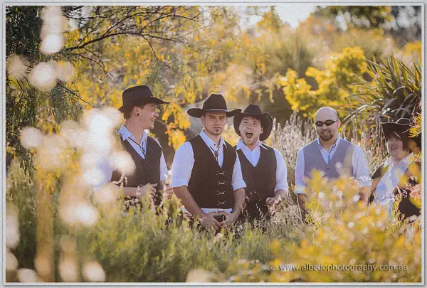Gary and his hatted mates clown for the camera among sunlit bushes and golden late-afternoon grass.