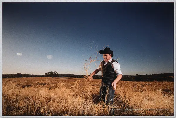 Gary flicks a spray of oat stalks into the air mid-field under a clear evening sky