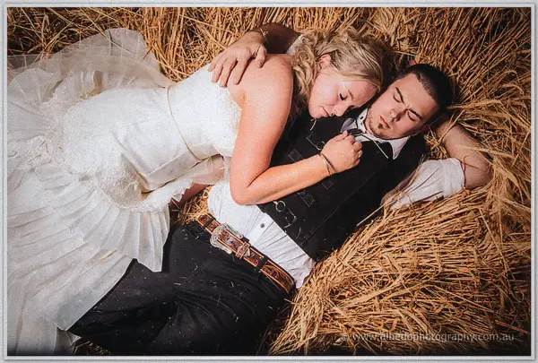 Seen from above, Tash rests her head on Gary's chest as they lie back in the hay