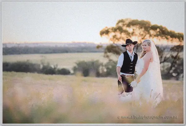 The couple pause in a soft-focus meadow at dusk, Gary twirling the closed parasol
