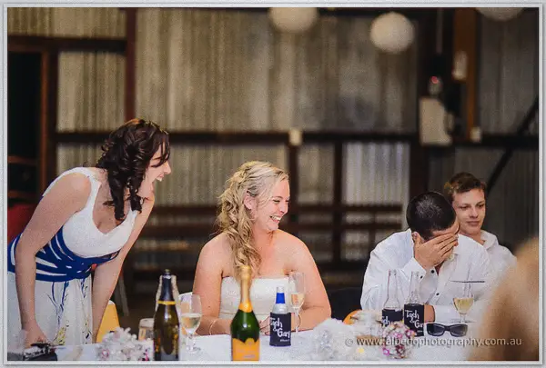 Tash cracks up at the bridal table as a groomsman buries his face beside her