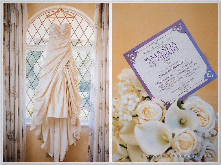 Amanda's ruched ivory gown hangs in an arched leadlight window beside her purple invitation