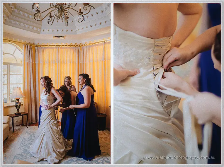 Bridesmaids in royal blue lace Amanda into her corseted gown beneath a chandelier; inset of the corset ties