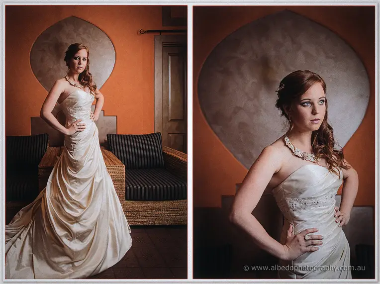 Amanda hands-on-hips portrait in warm rust tones beside a wicker daybed
