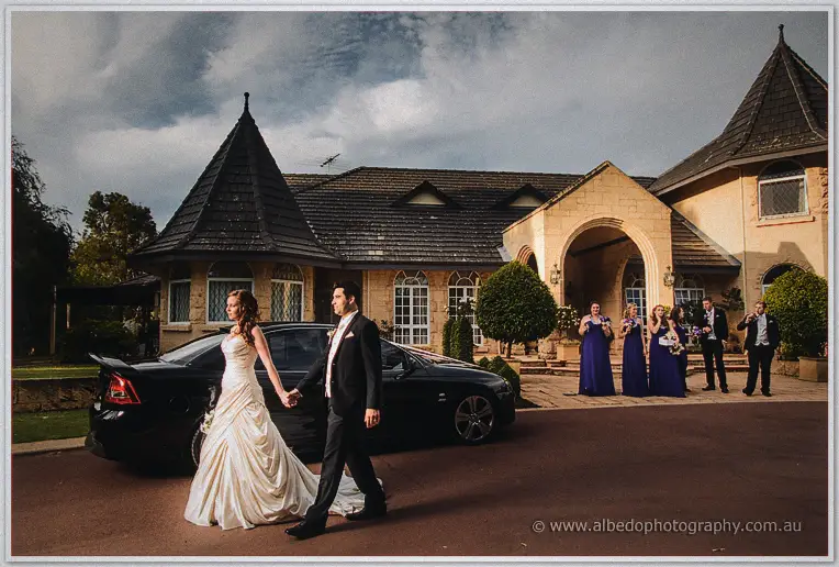 Amanda leads Craig from the car past applauding bridesmaids on the homestead drive