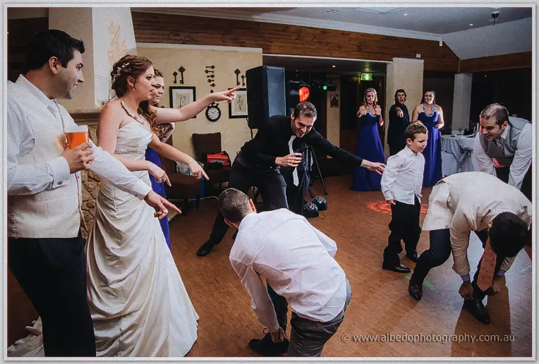 Amanda points across the floor as groomsmen and the page boy hunt for matching shoes