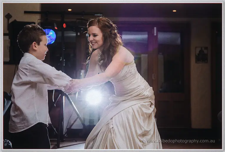 Amanda spins the young page boy across the dance floor in a burst of warm evening light