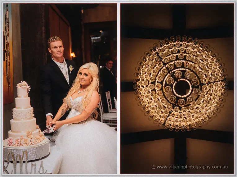 Steph and Luke cutting their rose-covered cake beside a wall of glowing candle lamps