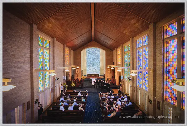 Wide view of St Boniface Cathedral's colourful stained glass and guests awaiting the ceremony