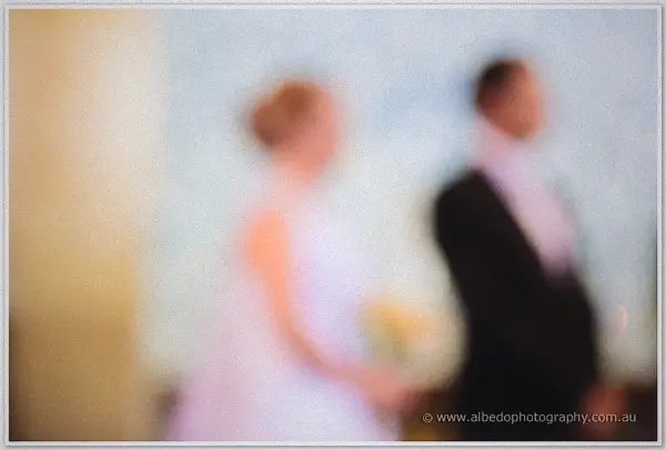 Soft-focus impression of Cayla and Joe standing together during their cathedral ceremony
