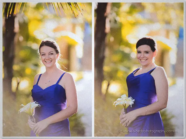 Two bridesmaids in purple-blue dresses beam beneath backlit palm fronds