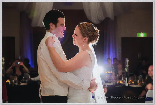 Cayla and Joe share their first dance, gazing at each other beneath the fabric canopy as flash flare blooms