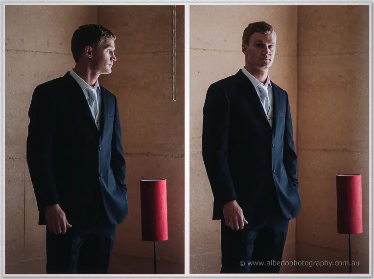 Diptych portraits of the groom in a dark suit beside a red lampshade, half in shadow against rammed earth