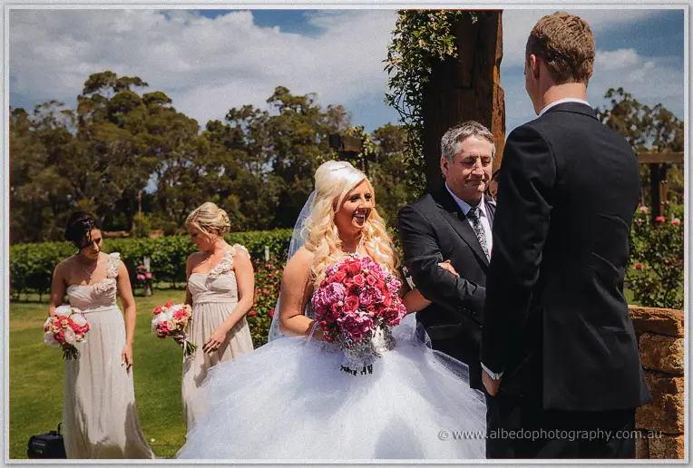 Steph reaches Luke at the altar as her father gives her away before the vineyard lawn.